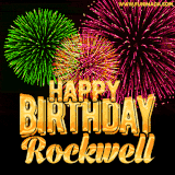 A captivating GIF with bursts of green, pink, and orange fireworks lighting up the night sky, accompanied by 'Happy Birthday Rockwell' in glowing golden text.