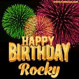 A captivating GIF with bursts of green, pink, and orange fireworks lighting up the night sky, accompanied by 'Happy Birthday Rocky' in glowing golden text.