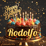 Close-up of a chocolate birthday cake with multicolored frosting swirls and colorful candy beads around the gold base. Greeting text with name Rodolfo