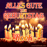 An animated GIF featuring 'Alles Gute Zum Geburtstag Rook' in glowing red and gold letters above a cake with colorful lit candles, set against a festive sparkling background.