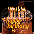 A rich chocolate cake topped with glowing birthday candles and surrounded by bright fireworks. The animated GIF displays the message 'Happy Birthday Rory' in golden text.