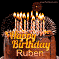 A rich chocolate cake topped with glowing birthday candles and surrounded by bright fireworks. The animated GIF displays the message 'Happy Birthday Ruben' in golden text.