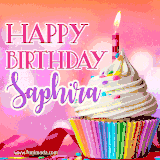 A vibrant birthday GIF featuring a rainbow-colored cupcake topped with white frosting, sprinkles, and a lit candle. The text reads 'Happy Birthday Saphira' in bold pink and violet letters with white outline.
