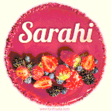 Beautifully decorated red velvet berry birthday cake with vibrant fruits and a glowing 'Sarahi' name, adding a touch of sweetness and sparkle.