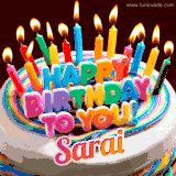 A colorful birthday cake topped with lit candles, with the words 'Happy Birthday Sarai' in bold glowing letters on a burgundy background. Animated flames add a festive touch.