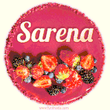 Beautifully decorated red velvet berry birthday cake with vibrant fruits and a glowing 'Sarena' name, adding a touch of sweetness and sparkle.