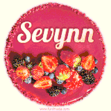 Beautifully decorated red velvet berry birthday cake with vibrant fruits and a glowing 'Sevynn' name, adding a touch of sweetness and sparkle.