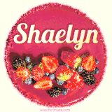 Beautifully decorated red velvet berry birthday cake with vibrant fruits and a glowing 'Shaelyn' name, adding a touch of sweetness and sparkle.