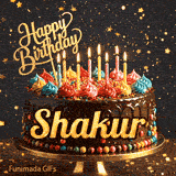 A decorated birthday cake with colorful frosting rosettes, glowing candles, and a golden Happy Birthday topper with the name Shakur.