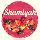 Beautifully decorated red velvet berry birthday cake with vibrant fruits and a glowing 'Shamiyah' name, adding a touch of sweetness and sparkle.