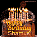 A rich chocolate cake topped with glowing birthday candles and surrounded by bright fireworks. The animated GIF displays the message 'Happy Birthday Shamus' in golden text.