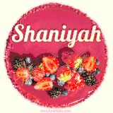 Beautifully decorated red velvet berry birthday cake with vibrant fruits and a glowing 'Shaniyah' name, adding a touch of sweetness and sparkle.