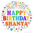 Happy Birthday Shanya' GIF with rainbow-colored letters, colorful stars, and fireworks on white background.