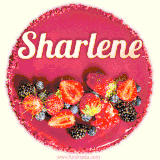 Beautifully decorated red velvet berry birthday cake with vibrant fruits and a glowing 'Sharlene' name, adding a touch of sweetness and sparkle.