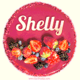 Beautifully decorated red velvet berry birthday cake with vibrant fruits and a glowing 'Shelly' name, adding a touch of sweetness and sparkle.