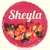 Beautifully decorated red velvet berry birthday cake with vibrant fruits and a glowing 'Sheyla' name, adding a touch of sweetness and sparkle.