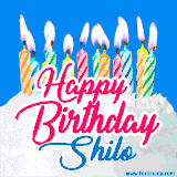 A cheerful animated GIF featuring colorful lit birthday candles on a white cake, with the text 'Happy Birthday Shilo' in bold red and blue script on a bright blue background.