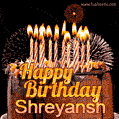 A rich chocolate cake topped with glowing birthday candles and surrounded by bright fireworks. The animated GIF displays the message 'Happy Birthday Shreyansh' in golden text.
