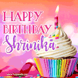 A vibrant birthday GIF featuring a rainbow-colored cupcake topped with white frosting, sprinkles, and a lit candle. The text reads 'Happy Birthday Shrinika' in bold pink and violet letters with white outline.
