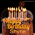 A rich chocolate cake topped with glowing birthday candles and surrounded by bright fireworks. The animated GIF displays the message 'Happy Birthday Shyne' in golden text.