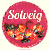 Beautifully decorated red velvet berry birthday cake with vibrant fruits and a glowing 'Solveig' name, adding a touch of sweetness and sparkle.