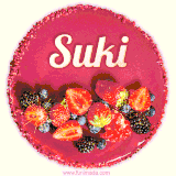 Beautifully decorated red velvet berry birthday cake with vibrant fruits and a glowing 'Suki' name, adding a touch of sweetness and sparkle.
