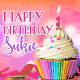 A vibrant birthday GIF featuring a rainbow-colored cupcake topped with white frosting, sprinkles, and a lit candle. The text reads 'Happy Birthday Sukie' in bold pink and violet letters with white outline.