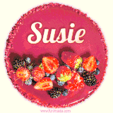 Beautifully decorated red velvet berry birthday cake with vibrant fruits and a glowing 'Susie' name, adding a touch of sweetness and sparkle.