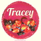 Beautifully decorated red velvet berry birthday cake with vibrant fruits and a glowing 'Tracey' name, adding a touch of sweetness and sparkle.