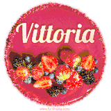 Beautifully decorated red velvet berry birthday cake with vibrant fruits and a glowing 'Vittoria' name, adding a touch of sweetness and sparkle.