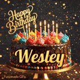 Chocolate cake with colorful icing swirls on top and the name Wesley written on the chocolate frosting under lit candles.