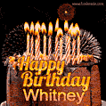 A rich chocolate cake topped with glowing birthday candles and surrounded by bright fireworks. The animated GIF displays the message 'Happy Birthday Whitney' in golden text.