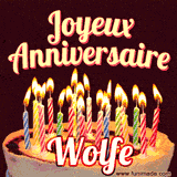 A Happy Birthday GIF in French featuring a festive birthday cake adorned with bright candles and the glowing text 'Joyeux Anniversaire Wolfe' in a cheerful style.