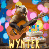 Animated birthday GIF showing a capybara playing guitar and singing beside a birthday cake with the name Wynter in large letters and colorful bokeh lights in the background.
