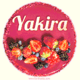 Beautifully decorated red velvet berry birthday cake with vibrant fruits and a glowing 'Yakira' name, adding a touch of sweetness and sparkle.