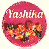 Beautifully decorated red velvet berry birthday cake with vibrant fruits and a glowing 'Yashika' name, adding a touch of sweetness and sparkle.