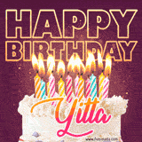 A colorful birthday cake topped with lit candles, with the words 'Happy Birthday Yitta' in bold glowing letters on a burgundy background. Animated flames add a festive touch.