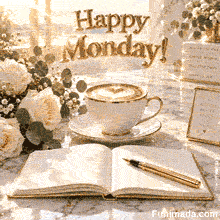 A premium animated morning GIF displaying a cup of steaming hot coffee with a heart pattern in the foam next to an open notebook, a gold fountain pen, and a bouquet of white roses under the text Happy Monday!.