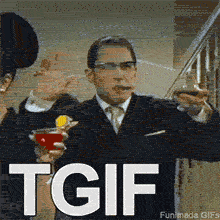 Tom Hardy as Reggie Kray from the movie 'Legend' in a suit and glasses, raising a brandy snifter and waving with a cigar in his mouth. The text 'TGIF' is at the bottom of the GIF.