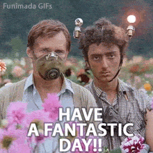 A man in a retro green gas mask and a young man with lit lightbulbs on his head stand among pink dahlias with deadpan expressions under Have a Fantastic Day text.