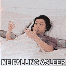 A woman lies in bed under white sheets, eyes half-open. She performs the viral '67' hand gesture in her sleep, moving her palms up and down like a scale. The text overlay reads 'ME FALLING ASLEEP'.